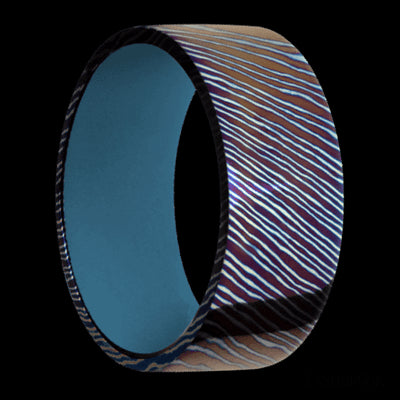 9 mm wide Flat Titanium Damascus band featuring a Royal Blue sleeve.